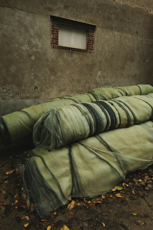 a pile of green tarps sitting next to a building