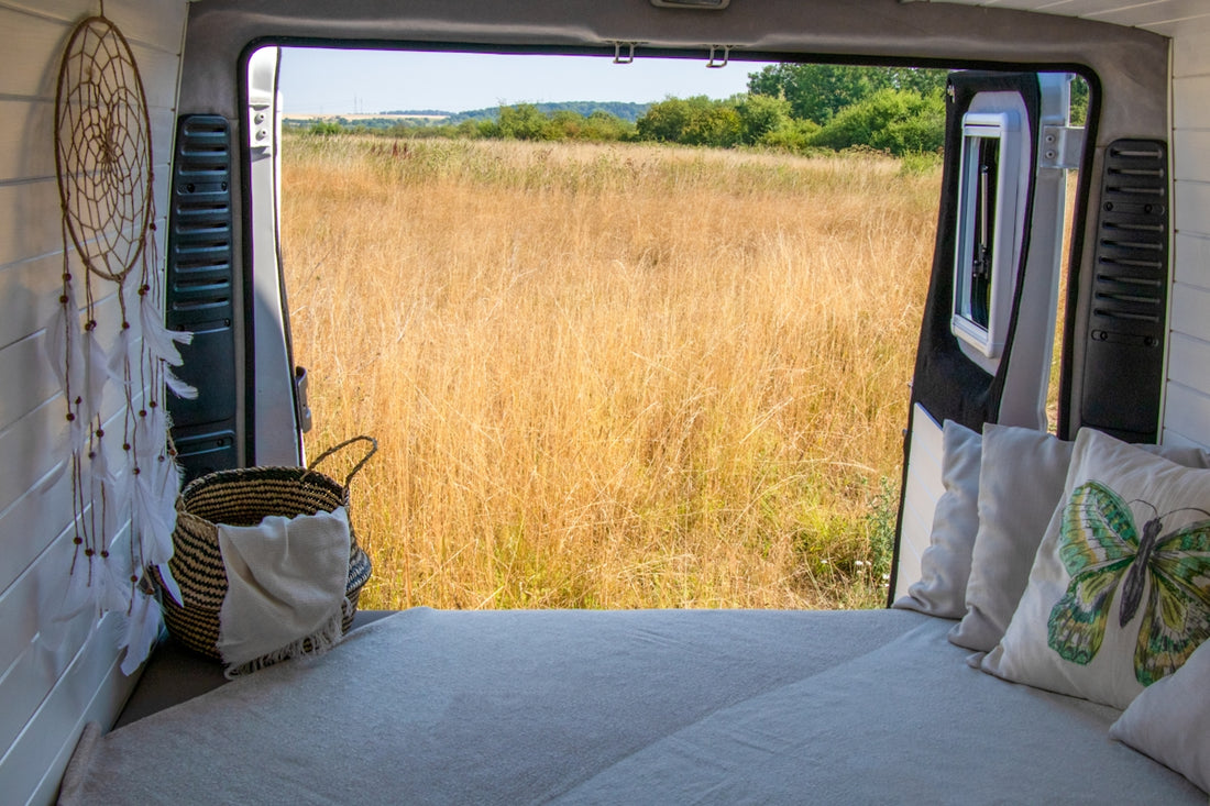 a bed in the back of a truck with a view of a field