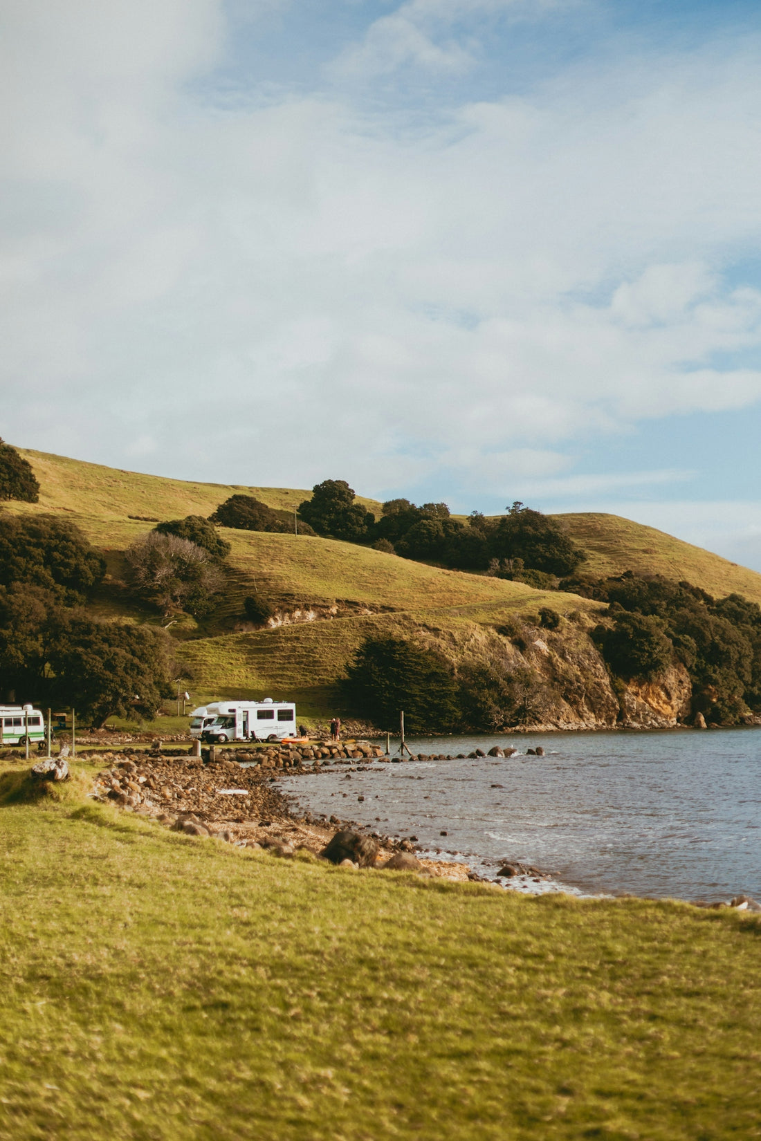 a couple of rvs parked on the side of a lake