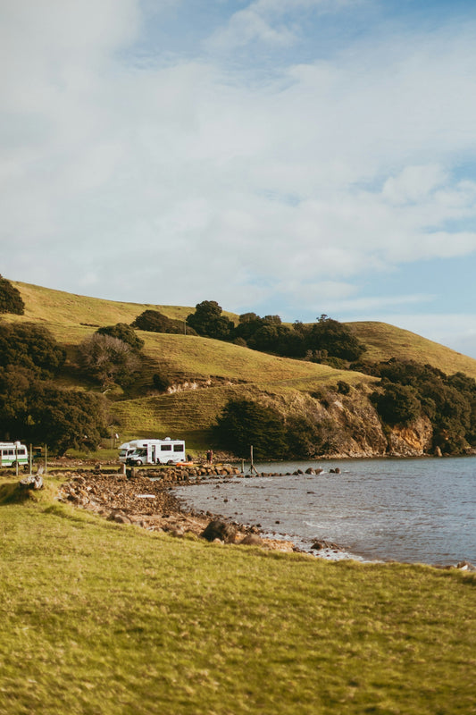 a couple of rvs parked on the side of a lake