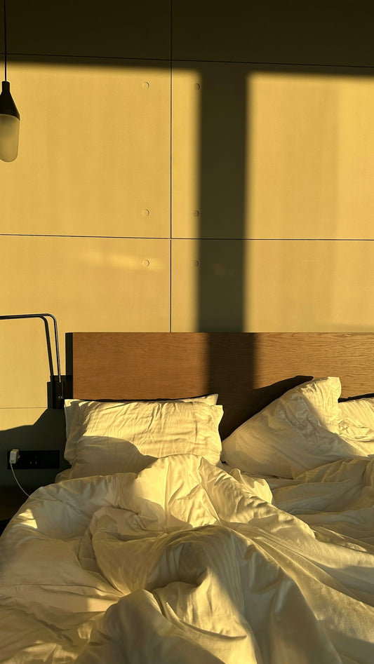 A bed with a white comforter and a lamp