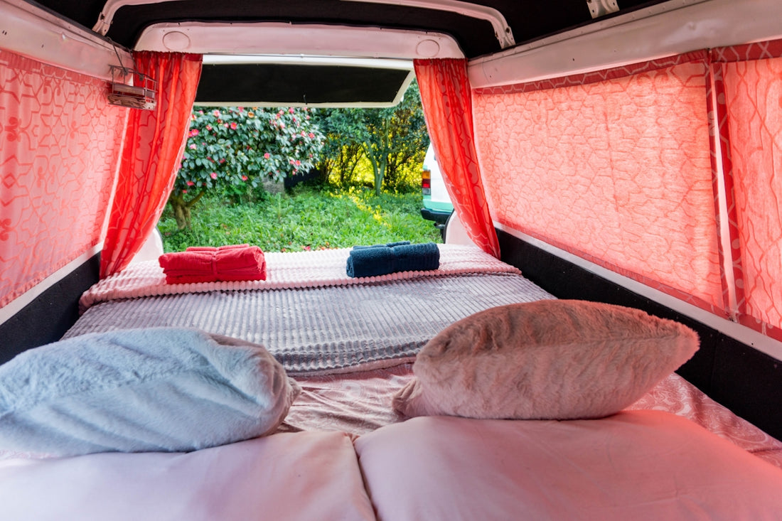A bed in a small room with red curtains