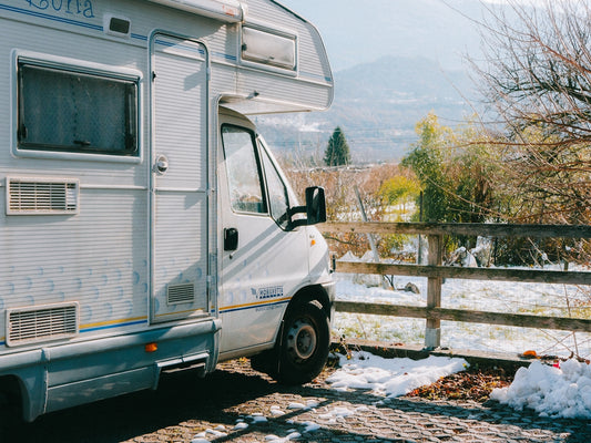 White camper van parked by a wooden fence