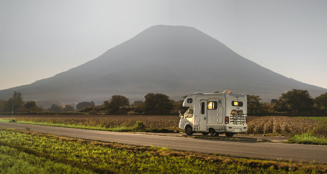 Camper van driving on road with mountain background